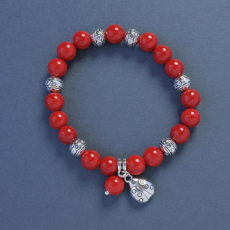Coral (pressed) Bracelet, diameter 9mm+/-, length 18cm+/- stretch with Ladybird charm