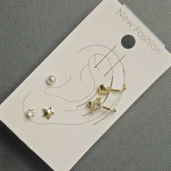 Earrings 'Studs and Connets' on earlobe with golden metal, white rhinestones and pearl