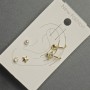 Earrings 'Studs and Connets' on earlobe with golden metal, white rhinestones and pearl