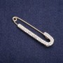 Brooch pin with white crystals 75x16mm+- golden metal