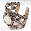 Bracelet made of mother-of-pearl with a wide curly metal frame and round bezel