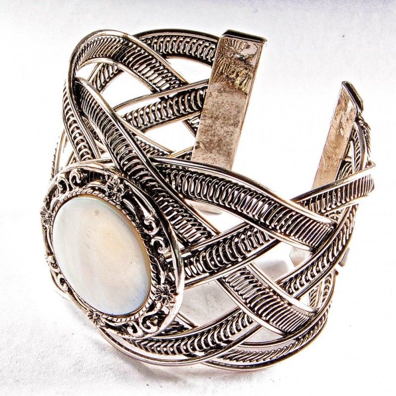 Bracelet made of mother-of-pearl with a wide curly metal frame and round bezel